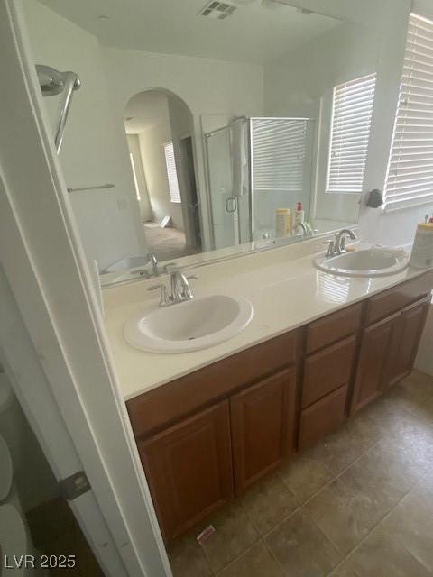 bathroom with vanity, a shower with shower door, and tile patterned flooring