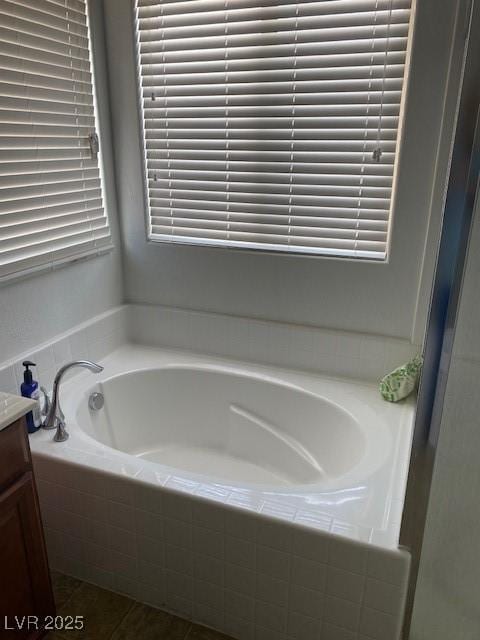 bathroom with vanity and tiled bath