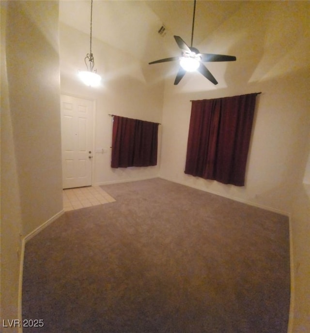 carpeted empty room featuring ceiling fan and vaulted ceiling