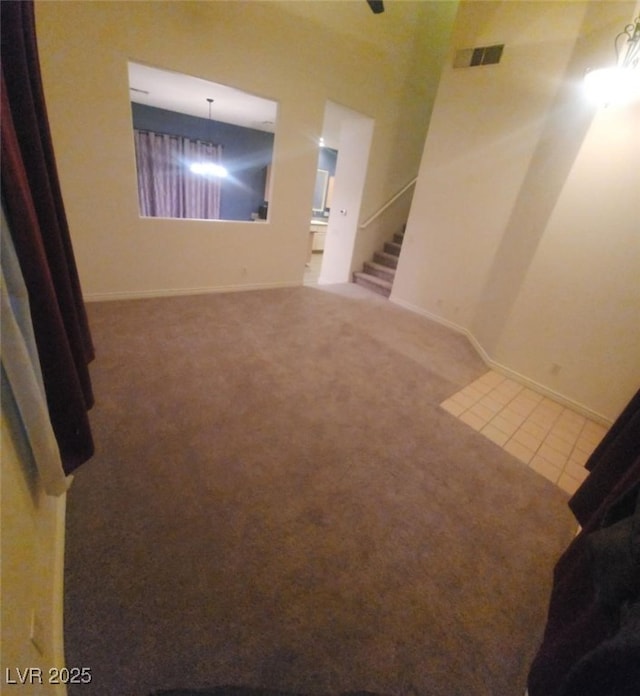 spare room with carpet flooring and an inviting chandelier