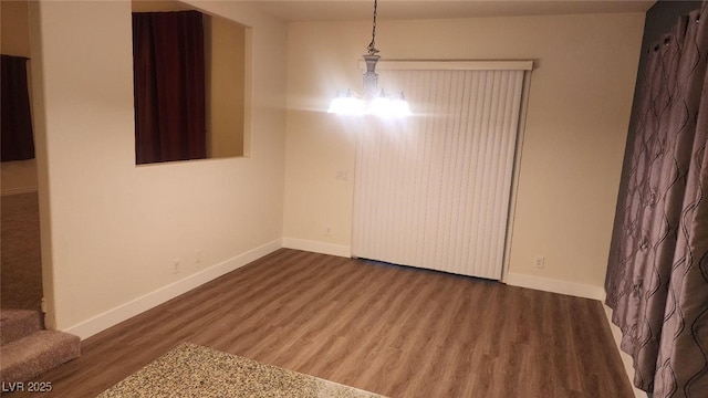 unfurnished dining area featuring a notable chandelier and hardwood / wood-style flooring