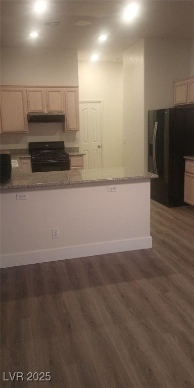 kitchen featuring black appliances, dark hardwood / wood-style floors, and light stone countertops