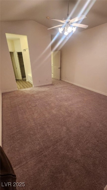 carpeted empty room featuring ceiling fan and lofted ceiling