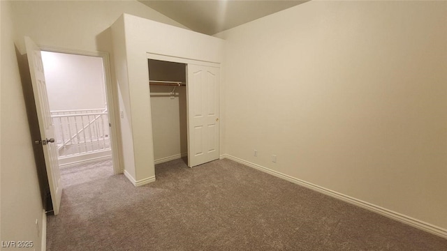 unfurnished bedroom with carpet, vaulted ceiling, and a closet