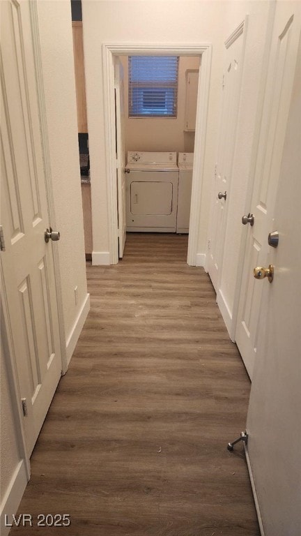 hall with washing machine and clothes dryer and dark wood-type flooring