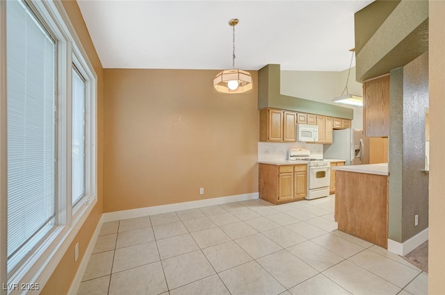 kitchen with pendant lighting, white appliances, vaulted ceiling, and light tile patterned flooring