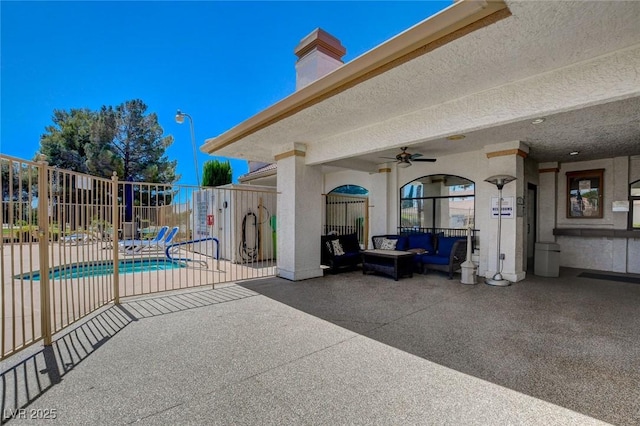 view of patio / terrace featuring ceiling fan, an outdoor living space, and a pool