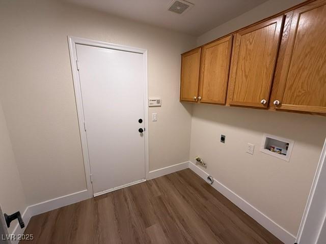 washroom featuring dark hardwood / wood-style flooring, hookup for a washing machine, cabinets, and hookup for an electric dryer