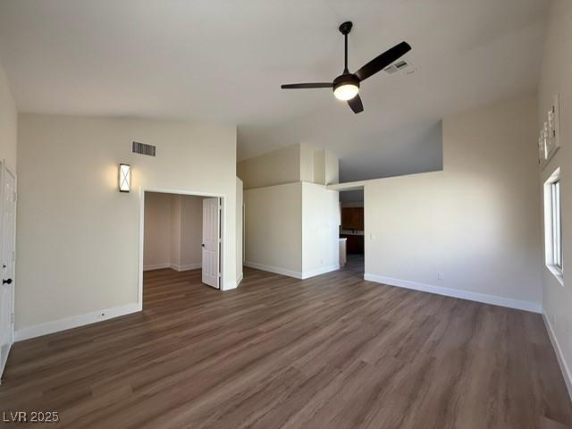 unfurnished living room with ceiling fan, dark hardwood / wood-style flooring, and lofted ceiling