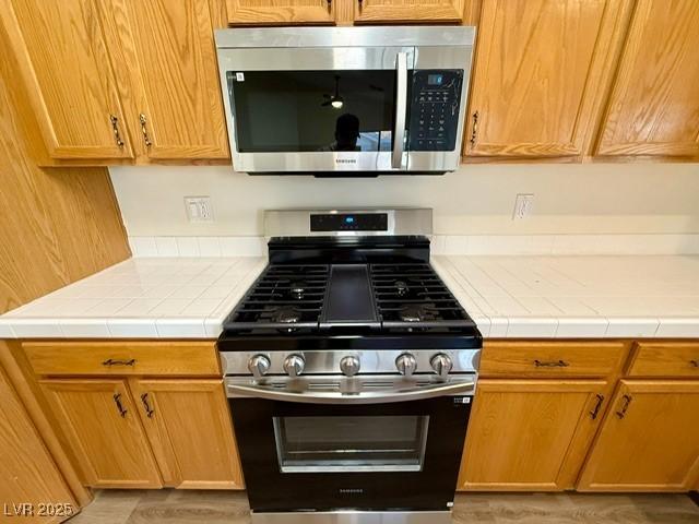 kitchen featuring tile countertops and stainless steel appliances