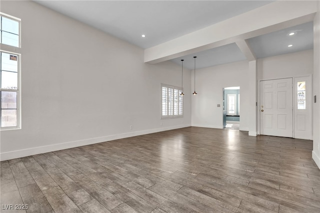 unfurnished living room with beam ceiling and hardwood / wood-style floors