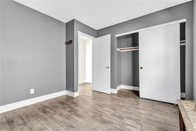 unfurnished bedroom featuring light hardwood / wood-style flooring and a closet