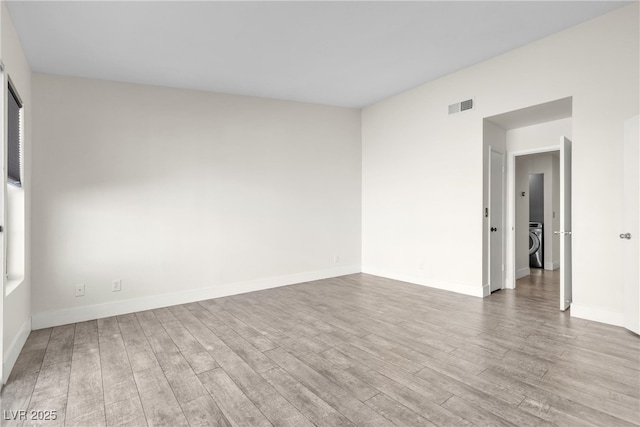 spare room with light wood-type flooring and washer / dryer