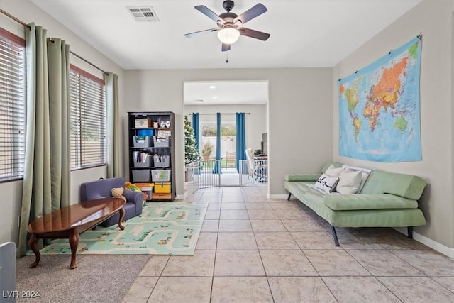 living area featuring ceiling fan, french doors, light tile patterned floors, and a healthy amount of sunlight