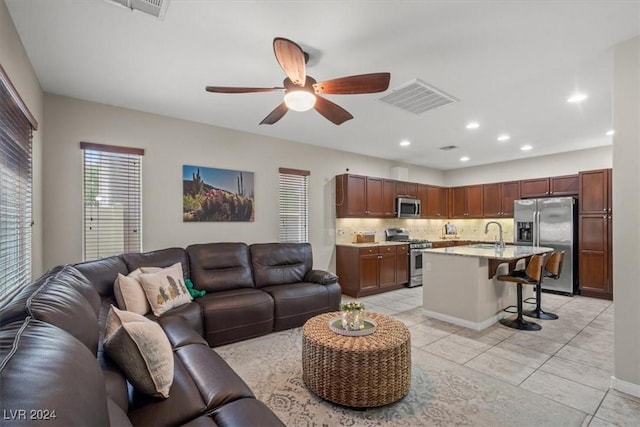 tiled living room featuring ceiling fan and sink