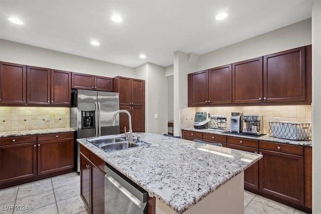 kitchen with dishwasher, a center island with sink, sink, tasteful backsplash, and light stone counters