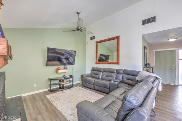 living room with hardwood / wood-style flooring, vaulted ceiling, and ceiling fan