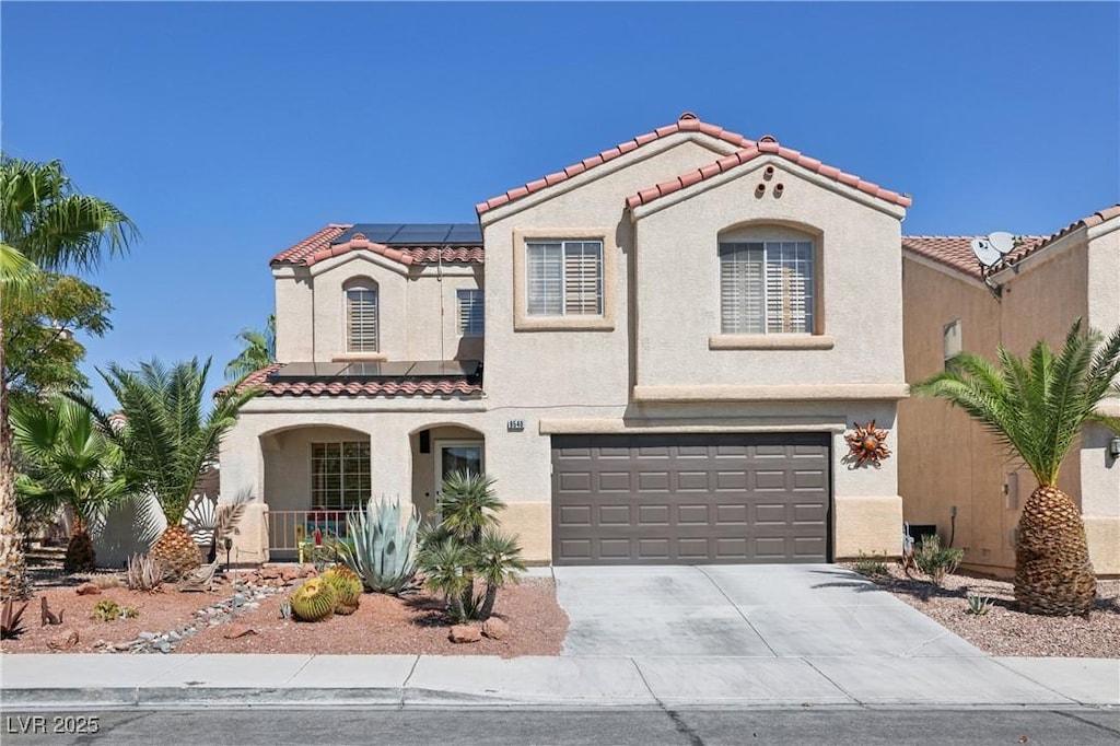 mediterranean / spanish-style house with covered porch, solar panels, and a garage