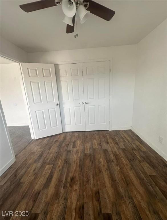 unfurnished bedroom featuring ceiling fan, dark hardwood / wood-style floors, and a closet