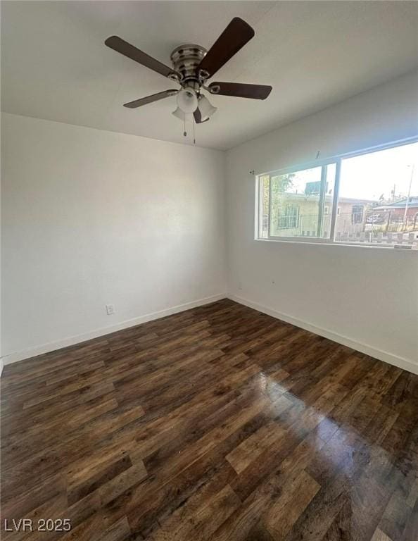 empty room featuring ceiling fan and dark hardwood / wood-style flooring