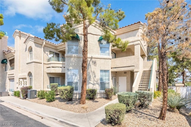 view of front of home featuring a balcony and central air condition unit