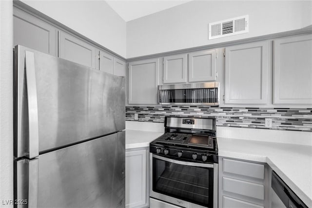 kitchen featuring backsplash, gray cabinetry, and stainless steel appliances