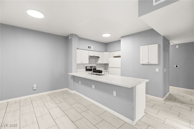 kitchen featuring white cabinets, kitchen peninsula, white fridge, and sink