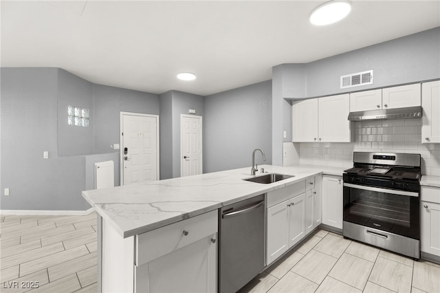 kitchen featuring white cabinets, sink, light stone counters, kitchen peninsula, and stainless steel appliances