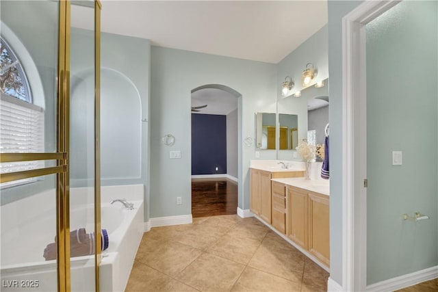 bathroom with a tub to relax in, ceiling fan, tile patterned flooring, and vanity