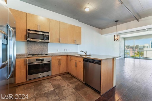 kitchen featuring kitchen peninsula, light stone countertops, stainless steel appliances, sink, and decorative light fixtures