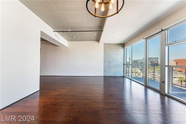 unfurnished room with dark hardwood / wood-style floors and a notable chandelier