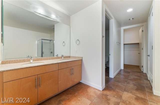 bathroom featuring vanity, toilet, and a shower with shower door