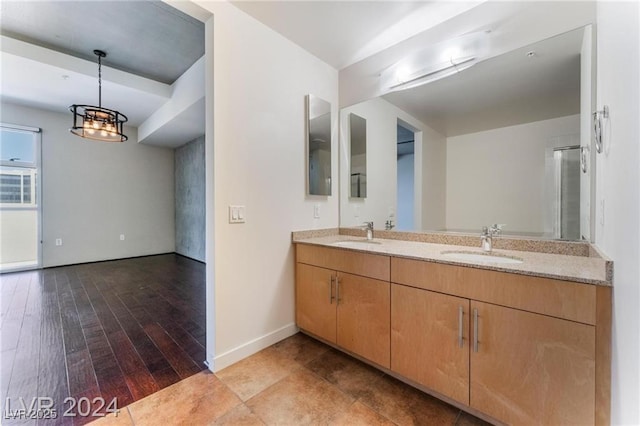 bathroom with hardwood / wood-style flooring, a notable chandelier, and vanity