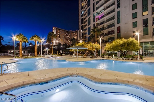 pool at night with a patio area