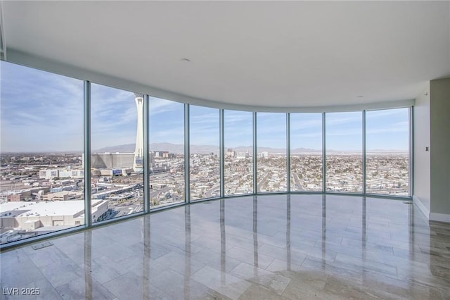 unfurnished room featuring plenty of natural light and a wall of windows