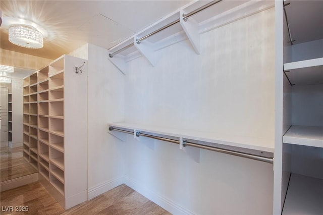 walk in closet featuring a notable chandelier