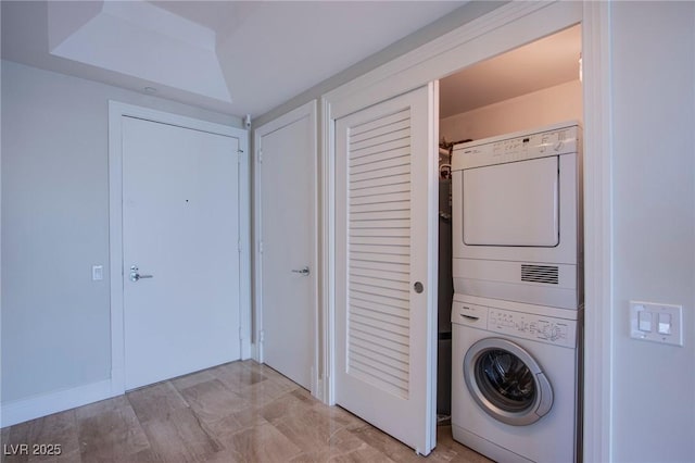 clothes washing area featuring stacked washer and clothes dryer