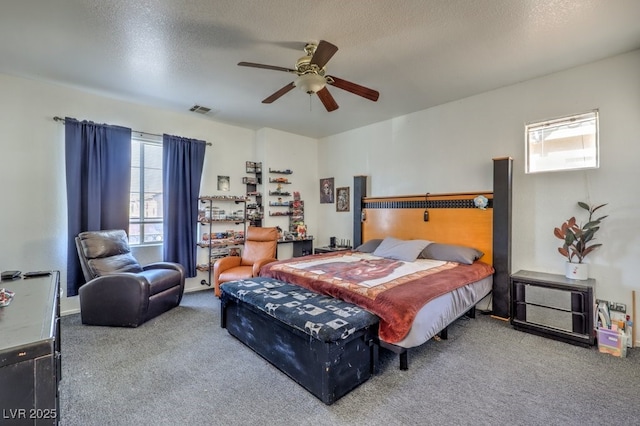 carpeted bedroom featuring a textured ceiling and ceiling fan