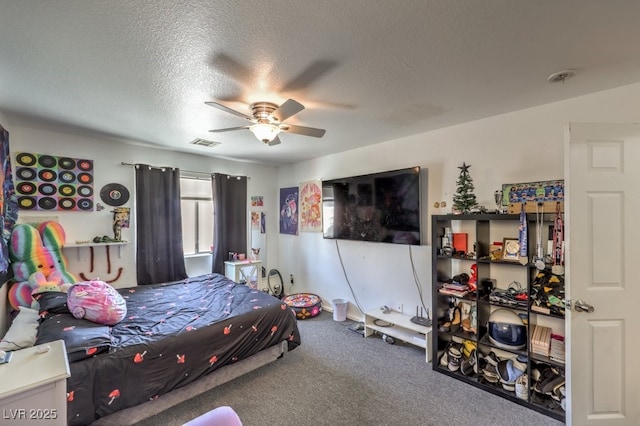 carpeted bedroom with ceiling fan and a textured ceiling