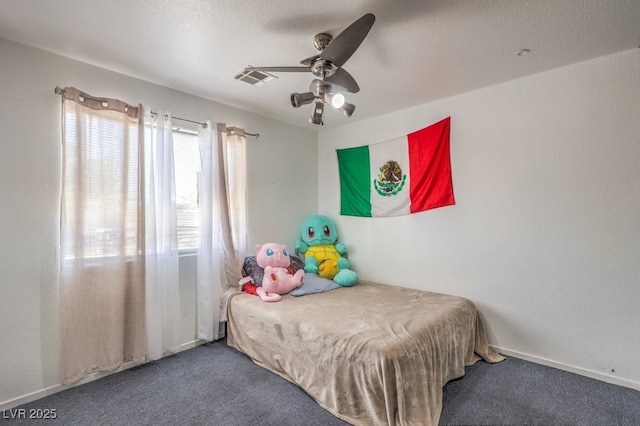 carpeted bedroom featuring ceiling fan and a textured ceiling