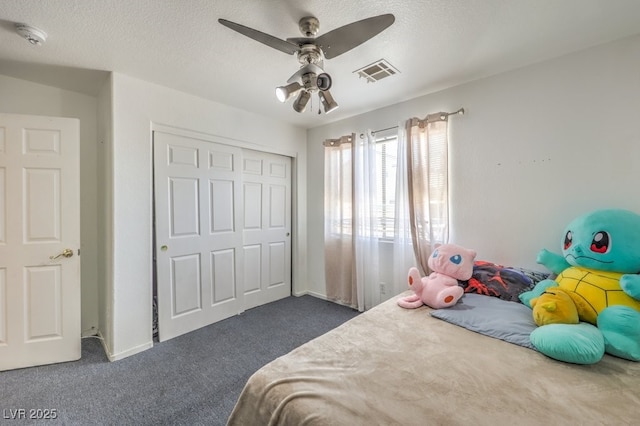 carpeted bedroom with ceiling fan, a closet, and a textured ceiling