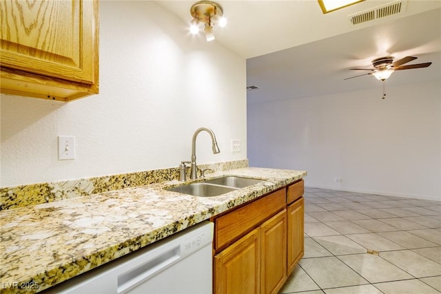 kitchen featuring white dishwasher, sink, ceiling fan, light stone countertops, and light tile patterned flooring