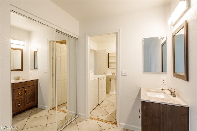 bathroom with washing machine and clothes dryer, tile patterned floors, and vanity