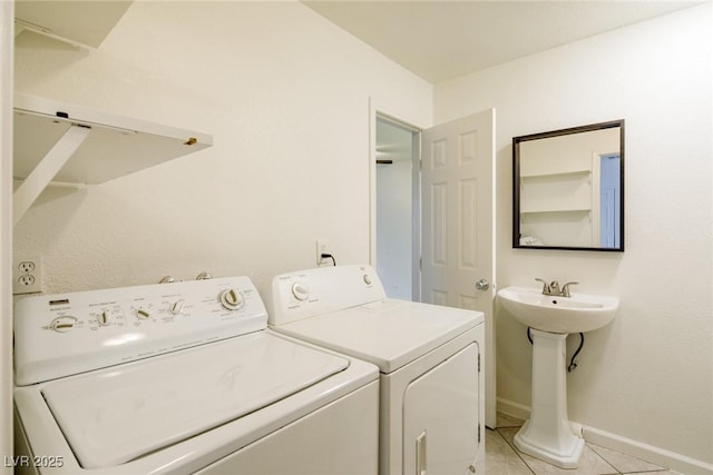 washroom featuring separate washer and dryer, sink, and light tile patterned floors