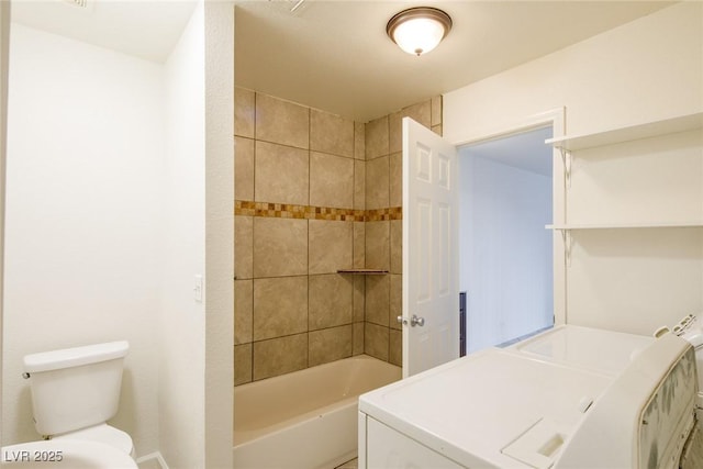 bathroom featuring toilet, tiled shower / bath combo, and independent washer and dryer