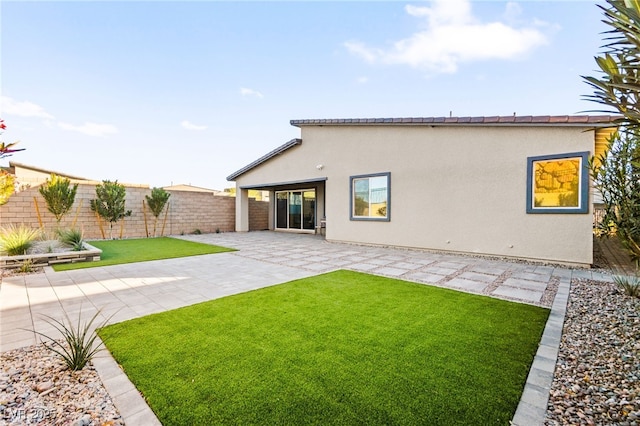 rear view of property with a patio area and a lawn