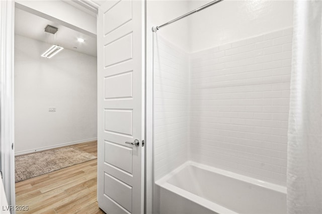 bathroom with shower / bath combination with curtain and wood-type flooring