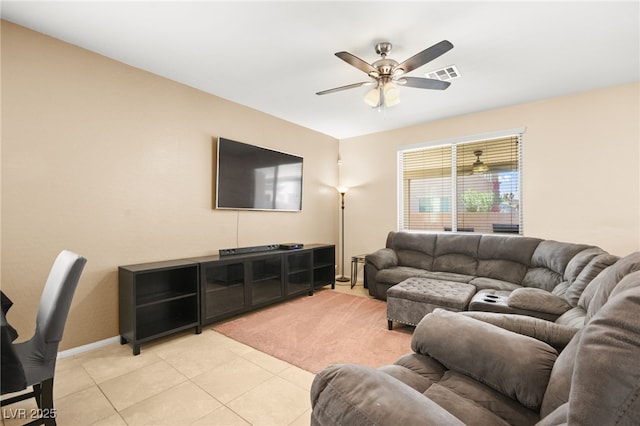 living room featuring visible vents, light carpet, a ceiling fan, light tile patterned floors, and baseboards