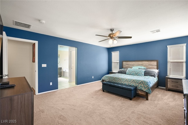 carpeted bedroom with ensuite bath and ceiling fan