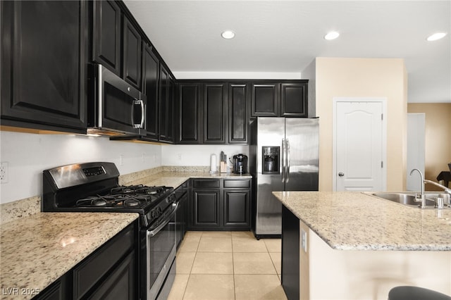 kitchen with light stone countertops, appliances with stainless steel finishes, light tile patterned floors, and sink